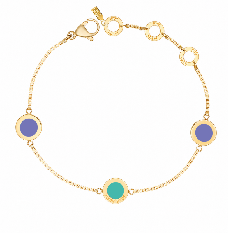 Gold chain bracelet with two circular Persian blue charms and a turquoise charm.