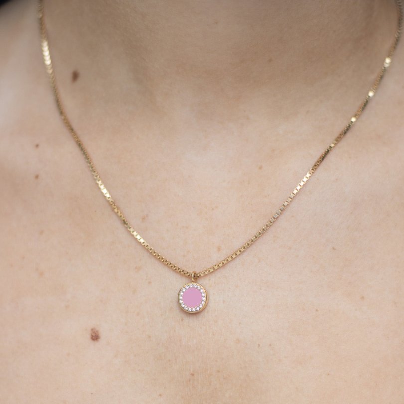 Woman wearing a Jason Hyde round pink enamel pendant 