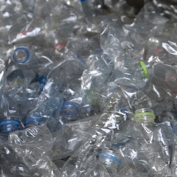 Pile of crushed clear plastic water bottles ready for upcycling into Jason Hyde eco accessories.