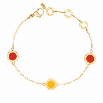 Gold chain bracelet with two red circular charms and one yellow charm.