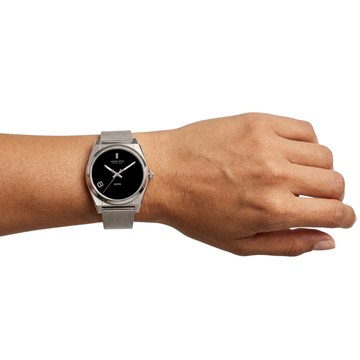 Silver Jason Hyde wristwatch with black face and mesh band on a wrist.