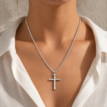 Close-up of a model wearing a Jason Hyde silver cross pendant necklace with a white collared shirt.
