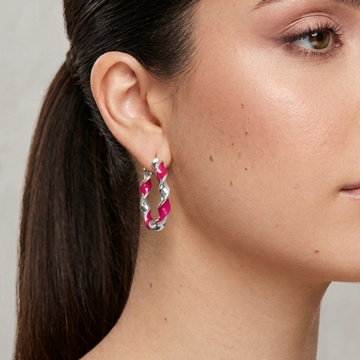 Jason Hyde silver twisted hoop earring with recycled pink plastic inlay worn by a model.