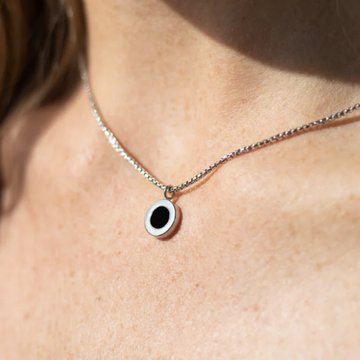 Elegant silver chain necklace featuring a circular black charm