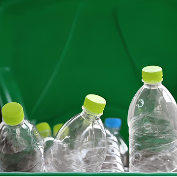 Clear plastic bottles with green caps inside a recycling bin