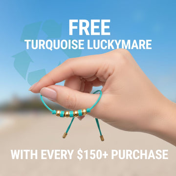 Hand holding turquoise bracelet with gold beads. Text reads: FREE TURQUOISE LUCKYMARE with every $150+ purchase.