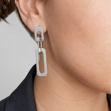 Close-up of a person wearing a sustainable silver-tone chain-link drop earring