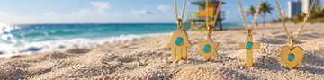 Four Jason Hyde gold pendant necklaces with turquoise ocean plastic chips standing on beach sand