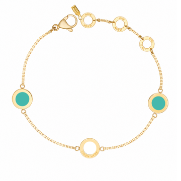 Gold chain bracelet with two circular turquoise charms and a white charm.