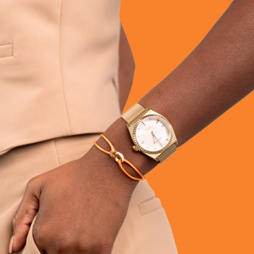 Close-up of a wrist wearing a gold-tone Jason Hyde watch with a mesh strap