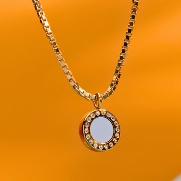 Minimalist gold box chain necklace with a circular pendant featuring a white recycled center 