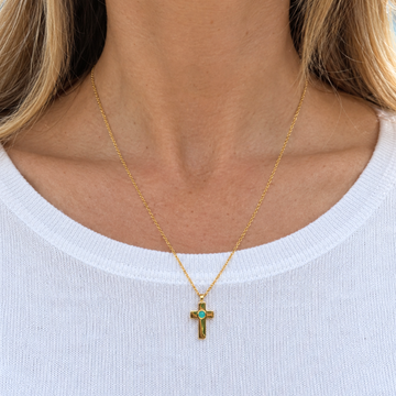 Woman wearing a Jason Hyde 18k gold-plated cross pendant necklace with a blue ocean plastic chip.