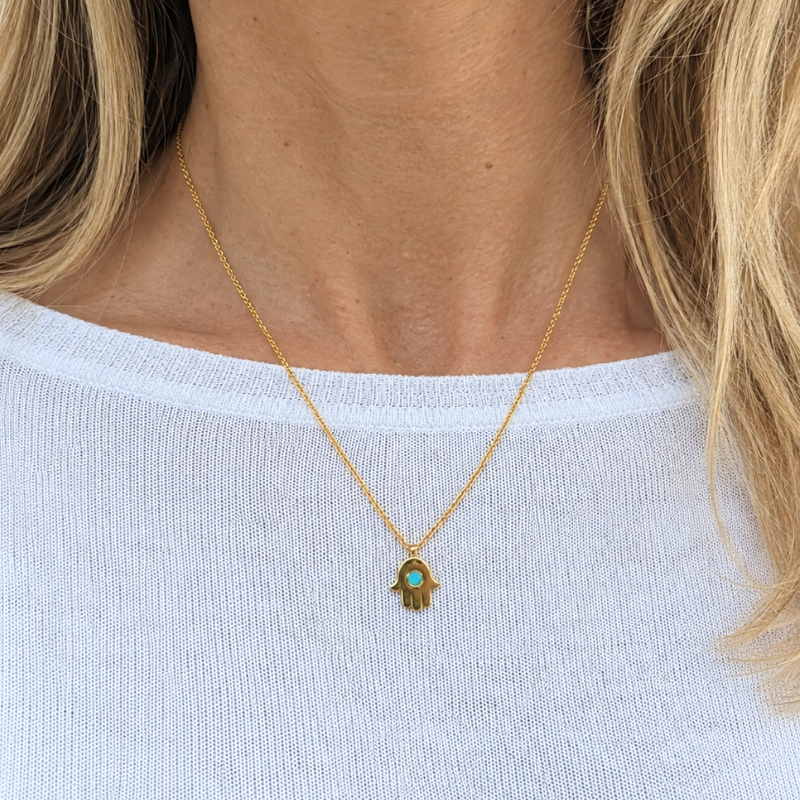 Sustainable 18k gold-plated hamsa necklace featuring a center turquoise chip.
