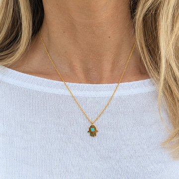 Sustainable 18k gold-plated hamsa necklace featuring a center turquoise chip.