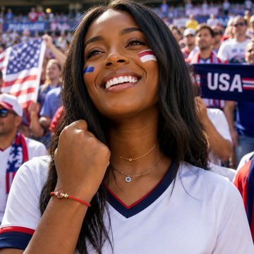 A smiling female soccer fan in a stadium cheering for the USA team, wearing a Jason Hyde jewelry