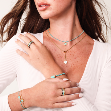 Woman wearing a turquoise and gold jewelry set 