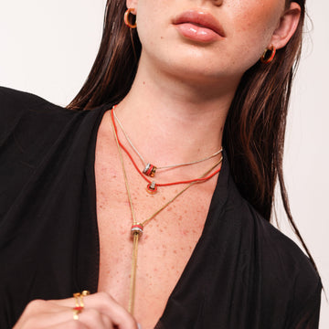 Woman wearing red JASON HYDE necklaces and hoops