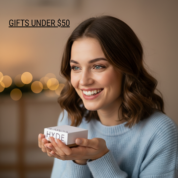 Woman in sweater against a Christmas background holding a Jason Hyde box