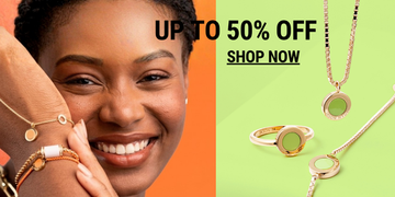 Smiling woman wearing gold jewelry next to green jewelry 50% off sale.