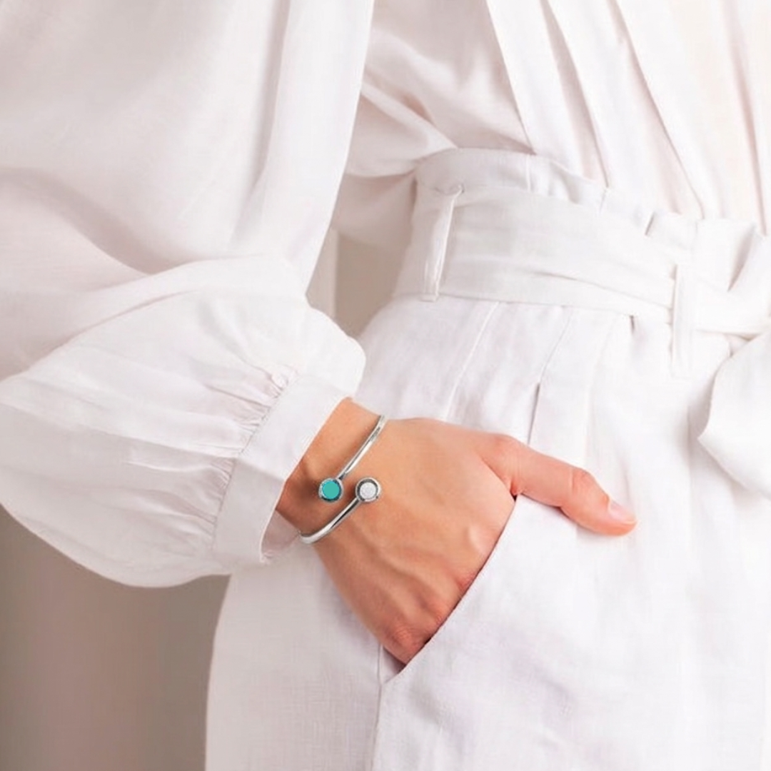 Woman wearing a silver bangle with turquoise and white chips