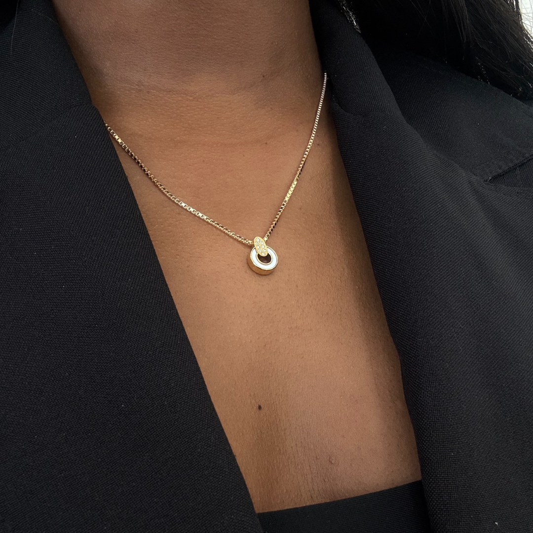 Delicate Nereida gold chain necklace and white chip on a woman's neck