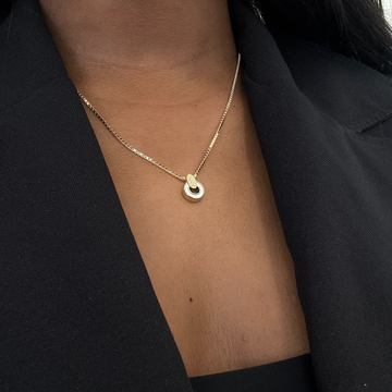 Delicate Nereida gold chain necklace and white chip on a woman's neck