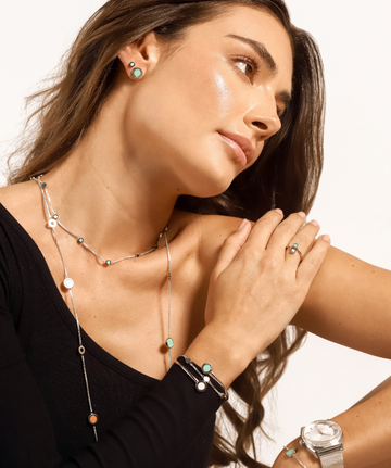woman with multicolor necklace and turquoise necklace, bangle in silver and white and turquoise, earrings, rings and silver watch